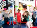 Des enfants apprennent à faire tourner des assiettes sur des bâtons lors d'un atelier cirque.
