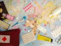 Une trousse de secours prête pour un voyage autour du monde : passeport, pansements, thermomètre, pilules, désinfectant et crème.