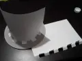 Chapeau en carton en cours de création, avec des pièces découpées et un patron.