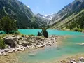 Un lac turquoise aux reflets émeraude, niché au cœur d'une vallée verdoyante des Pyrénées. Un paysage de carte postale, invitant à la contemplation.