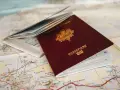 Un passeport français ouvert sur une carte. Pour aller à Rome, faut-il un passeport ? La réponse est oui si vous n'êtes pas citoyen de l'UE.