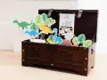 Coffre en bois rempli de décorations de dinosaures et de feuilles tropicales.
