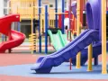 Aire de jeux colorée avec toboggans rouge, vert et violet.