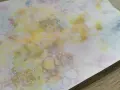 Peinture à bulles colorée sur papier blanc, avec des formes rondes et des éclaboussures.