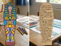 Sarcophage égyptien coloré et texte sur papyrus, sur une table avec des feutres.