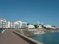 Vue de Jard-sur-Mer avec son port, ses immeubles blancs, son moulin et sa plage bordée de bateaux.