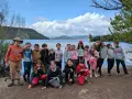 Groupe d'enfants souriants au bord d'un lac, une belle idée de projet éducatif en pleine nature.