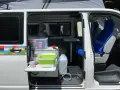 Aménagement intérieur d'un véhicule pour le transport de personnes moins de 9 places, avec coin cuisine et sièges.