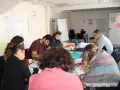 Groupe de personnes assises autour d'une table, travaillant sur des documents et un ordinateur portable.