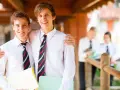 Deux adolescents souriants, portant des chemises blanches et des cravates, profitent de leurs vacances scolaires en Irlande.