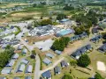 Vue aérienne d'une zone vacances Bretagne avec des maisons, une piscine et des espaces verts.