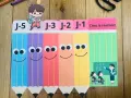 Illustration de crayons colorés souriants avec des étiquettes "J-5" à "J-1" et "C'est la rentrée!".