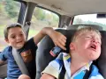 Un enfant pleure dans la voiture, son frère joue avec une petite voiture. Le temps de conduite chauffeur de bus est long pour certains.