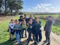 Groupe d'enfants souriants sur un chemin de terre, par une journée ensoleillée.
