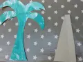 Palmier en carton turquoise et pièce de support beige sur fond étoilé.