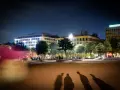 Ombre d'un mineur dehors la nuit, projetées sur une place éclairée par des bâtiments modernes.
