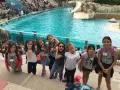 Des enfants en colonie de vacances en Île-de-France s'amusent devant un bassin de spectacle aquatique, faisant des grimaces.