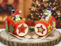 Deux traîneaux de Noël en carton décorés de pingouins, bonhommes de neige et rennes, sur un fond festif.