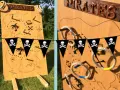 Jeu de kermesse à fabriquer gratuit : un panneau en bois décoré d'une carte au trésor pirate, avec des anneaux à lancer.