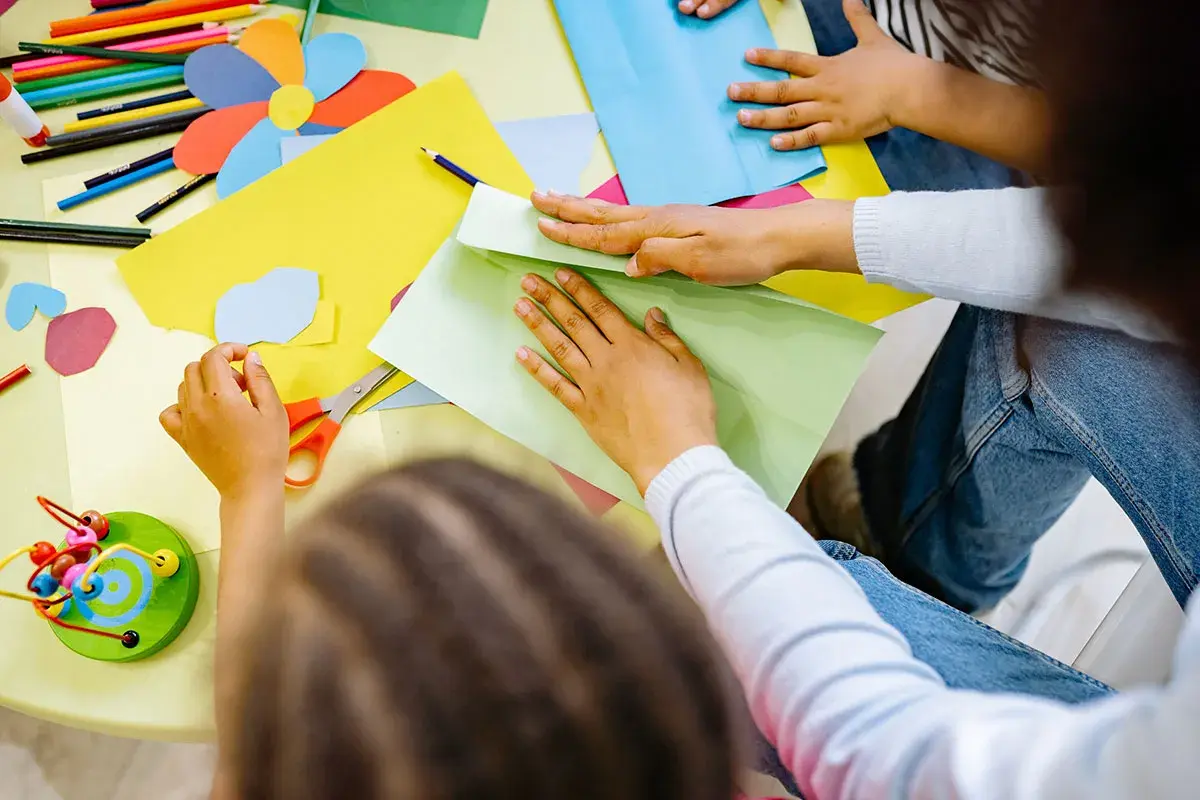 Exemple de projet d'animation en centre de loisirs : des enfants créent des formes colorées en papier.