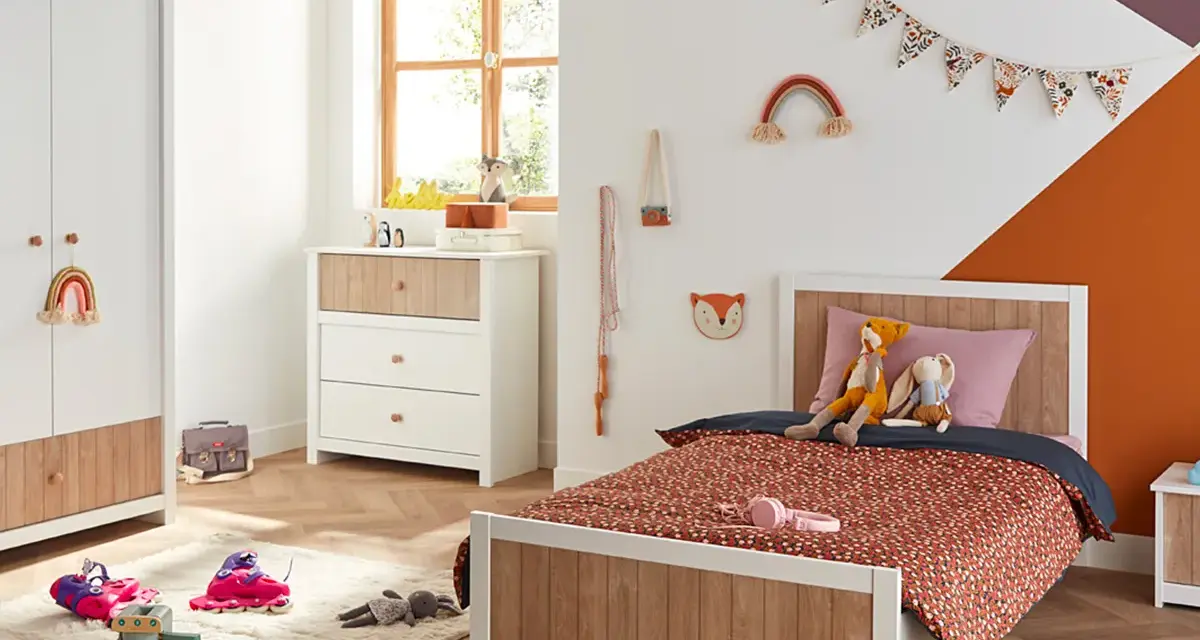 Chambre d'enfant décorée avec un lit, une commode, une armoire et des jouets.