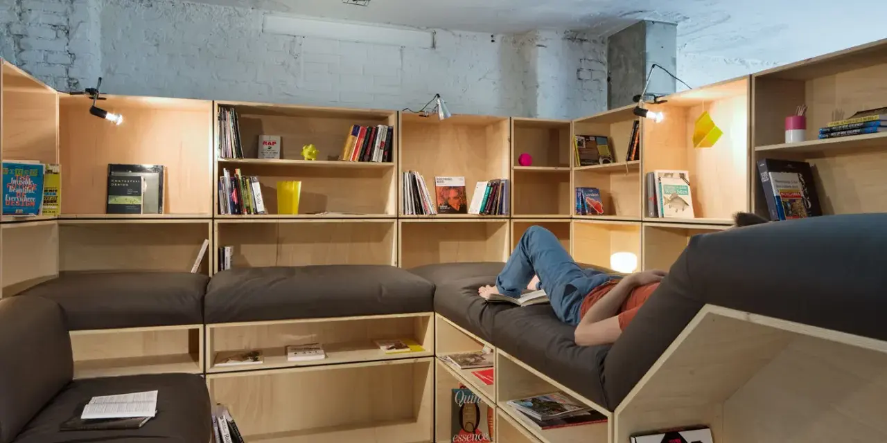 Aménagement d'une salle de loisirs avec étagères modulables et banquettes confortables.