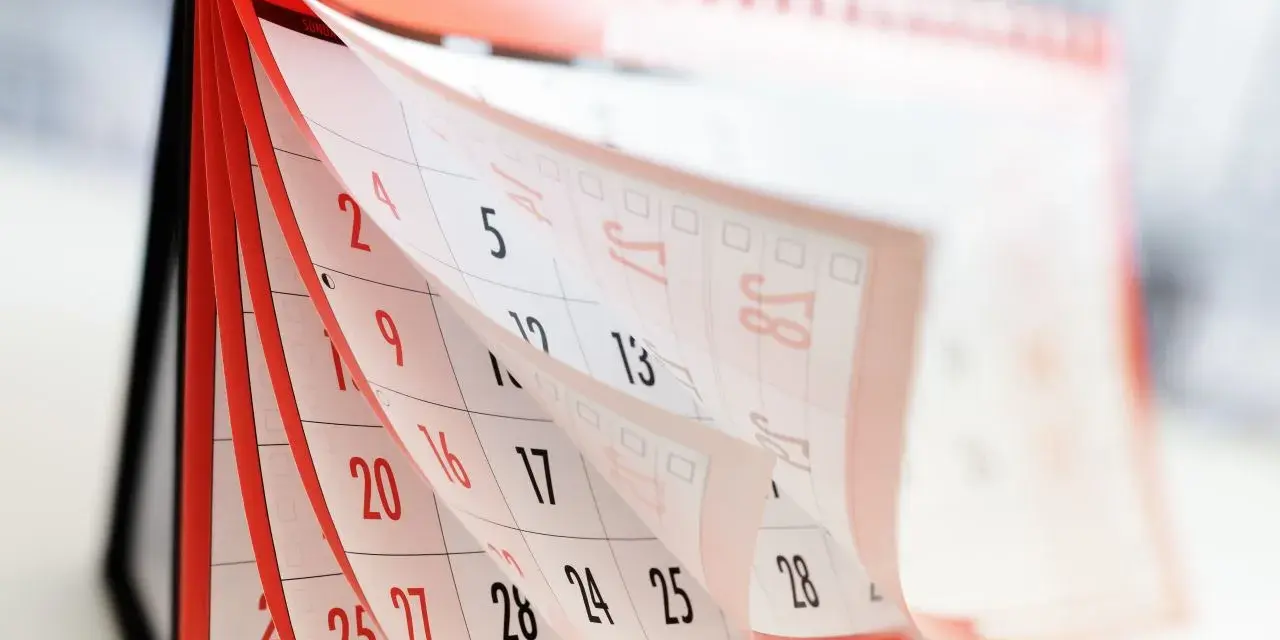 Calendrier de bureau avec pages qui tournent, montrant des dates.