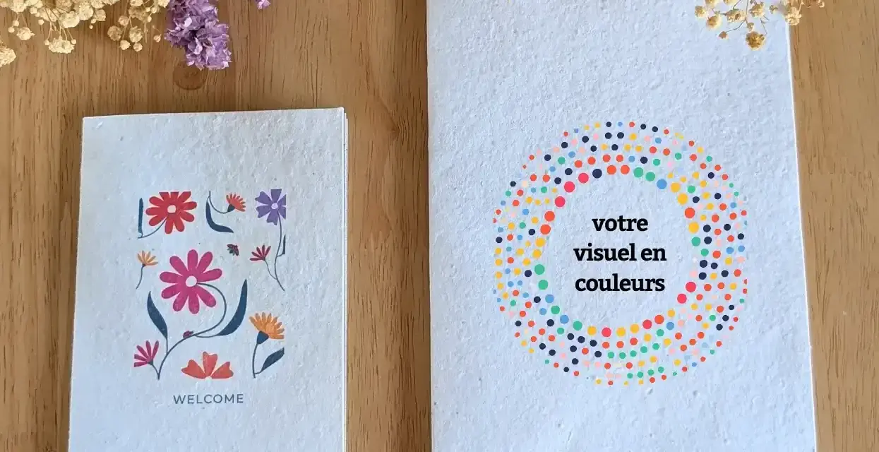 Deux carnets faits main sur fond de bois, décorés de fleurs et de points colorés.