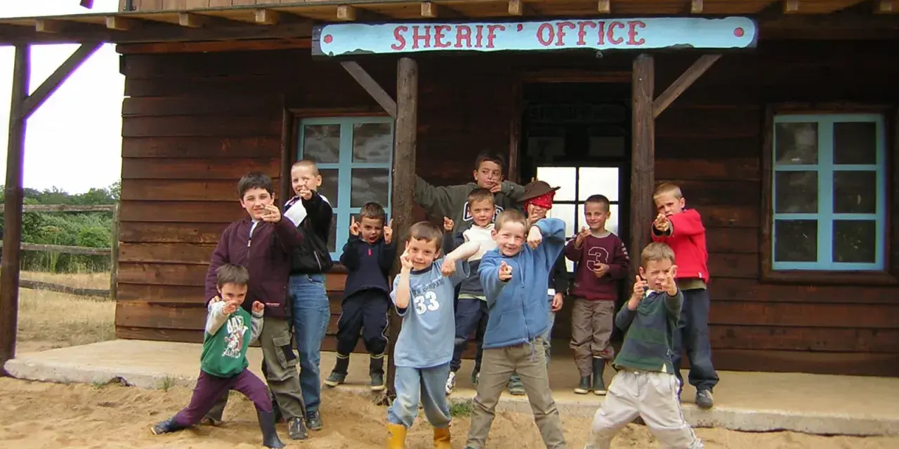 Groupe d'enfants devant un bureau de shérif western.