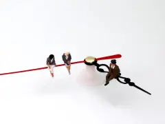 Trois figurines assises sur les aiguilles d'une horloge, symbolisant l'équivalence BAFD et la gestion du temps.