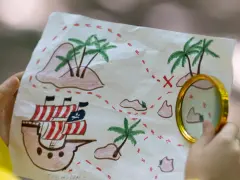 Carte au trésor dessinée, avec un bateau pirate, des îles et un X rouge. Parfait pour des jeux, des indices et des énigmes !