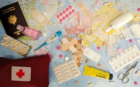 Une trousse de secours prête pour un voyage autour du monde : passeport, pansements, thermomètre, pilules, désinfectant et crème.