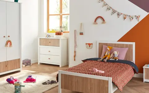 Chambre d'enfant décorée avec un lit, une commode, une armoire et des jouets.