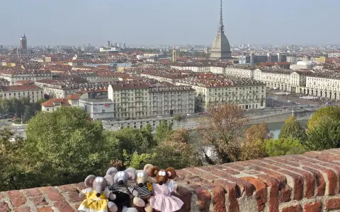Des souris en peluche profitent de la vue panoramique sur Turin, parfait pour un séjour de 3 jours. La Mole Antonelliana domine le paysage urbain.