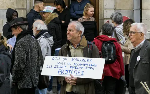 Un homme tient une pancarte "D'ici ou d'ailleurs, seuls ou accompagnés, les jeunes doivent être protégés", soutenant un centre d'accueil pour mineur.