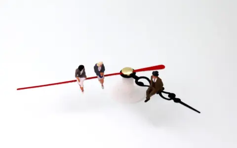 Trois figurines assises sur les aiguilles d'une horloge, symbolisant l'équivalence BAFD et la gestion du temps.
