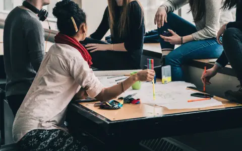 Groupe d'étudiants en formation uc direction bpjeps, travaillant sur un projet créatif avec des feutres et des schémas.
