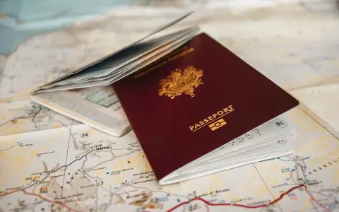 Un passeport français ouvert sur une carte. Pour aller à Rome, faut-il un passeport ? La réponse est oui si vous n'êtes pas citoyen de l'UE.