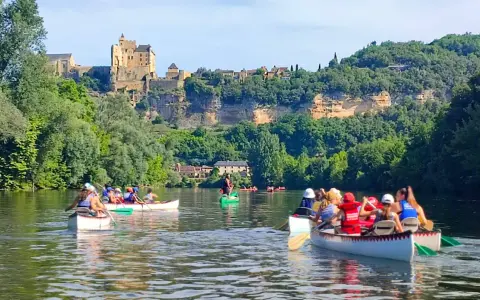 Des gens en canoë sur une rivière, avec un château en arrière-plan.