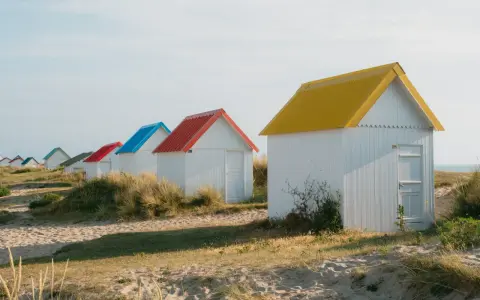Cabanes de plage colorées à Gouville-sur-Mer : découvrez les activités nautiques et les promenades sur le sable.