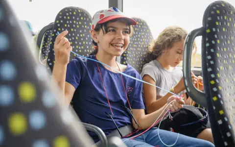 Deux enfants créatifs dans un bus, s'adonnant à une activité manuelle. Une belle illustration de l'éducation populaire en mouvement.