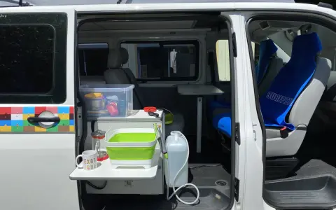 Aménagement intérieur d'un véhicule pour le transport de personnes moins de 9 places, avec coin cuisine et sièges.