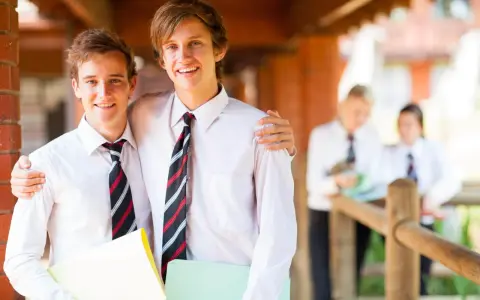 Deux adolescents souriants, portant des chemises blanches et des cravates, profitent de leurs vacances scolaires en Irlande.
