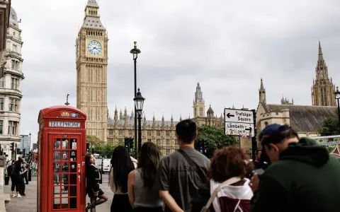 Cabine téléphonique rouge, Big Ben et touristes à Londres.