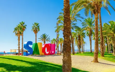 Bienvenue à Salou, Espagne ! Un endroit parfait pour une colonie de vacances ensoleillée, avec ses palmiers et son panneau coloré.