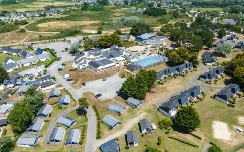Vue aérienne d'une zone vacances Bretagne avec des maisons, une piscine et des espaces verts.