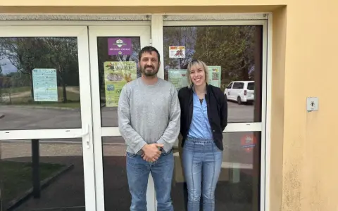 Le directeur du centre de loisirs et une collègue souriants devant l'entrée.