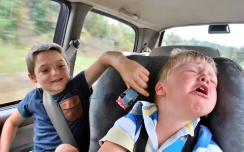 Un enfant pleure dans la voiture, son frère joue avec une petite voiture. Le temps de conduite chauffeur de bus est long pour certains.