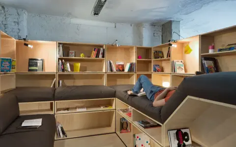 Aménagement d'une salle de loisirs avec étagères modulables et banquettes confortables.