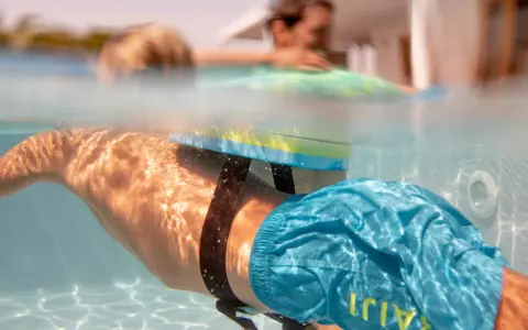 Plongeon sous-marin avec un dispositif de sécurité pour piscine, rappelant l'importance de la sécurité piscine réglementation pour tous.